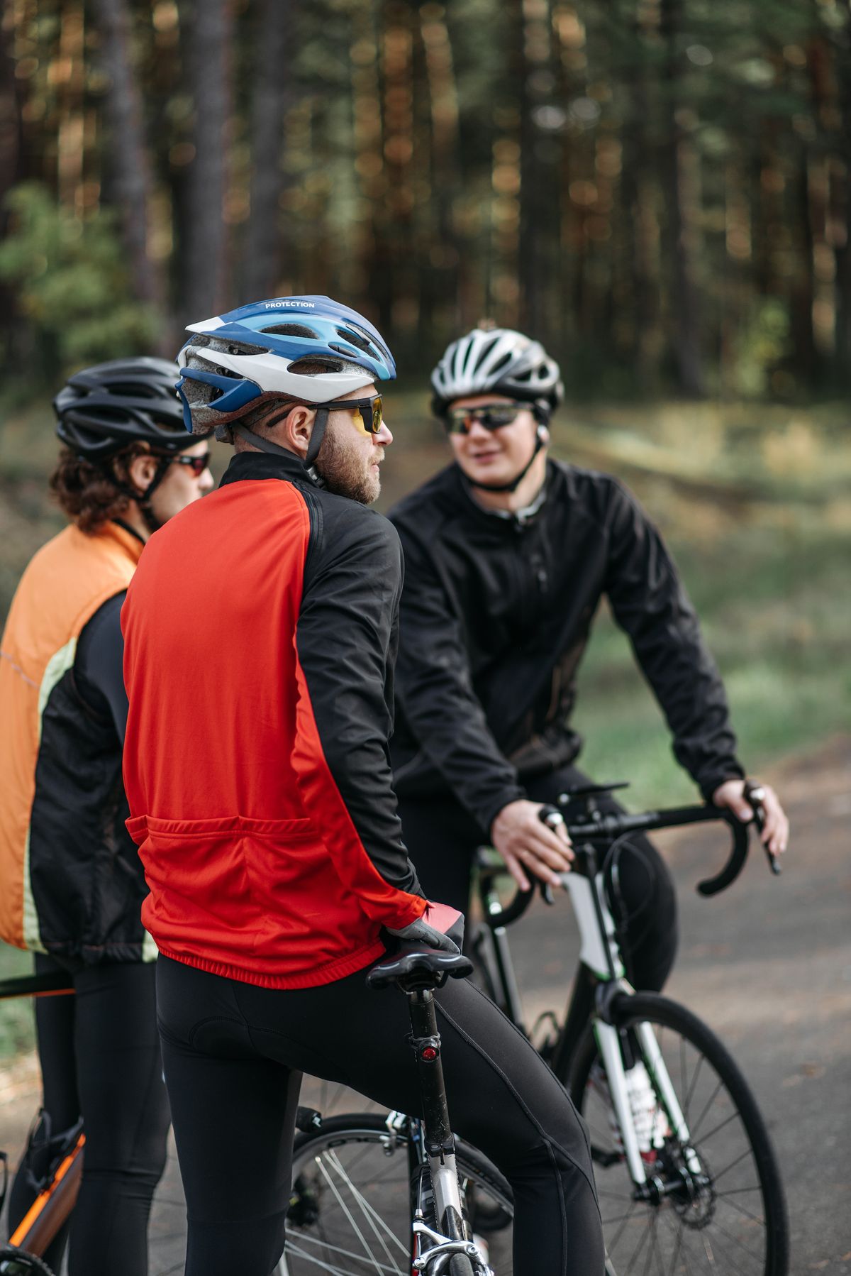 Road cyclists with racing bikes in a forest